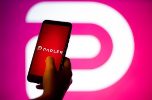 In this photo illustration a Parler App and logo is seen displayed on a smartphone and in the background. The 'free speech' social media platform, Parler, a hit with Trump supporters and an alternative to Twitter, stops working after losing support from A